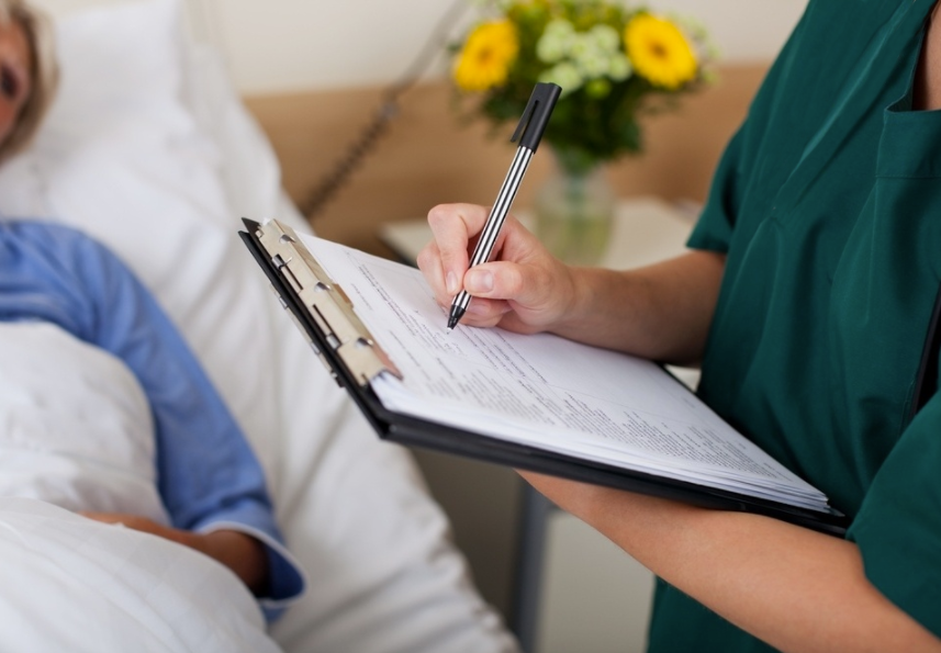 Nurse writing on a clipboard in a hospital